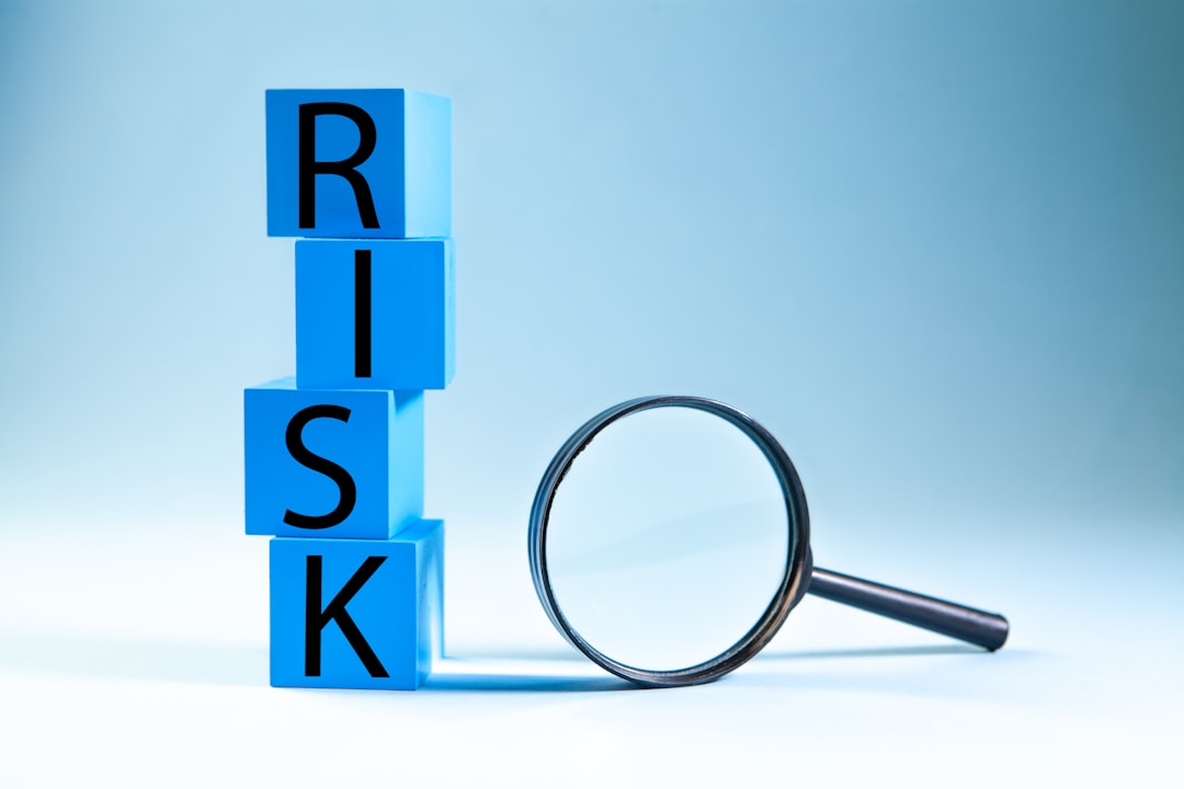 Business and finance concept. Word RISK on blue cubes with magnifying glass